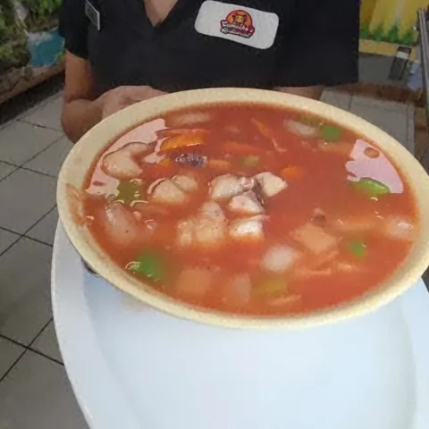 Server holding a bowl of caldo at Camacho's Restaurant