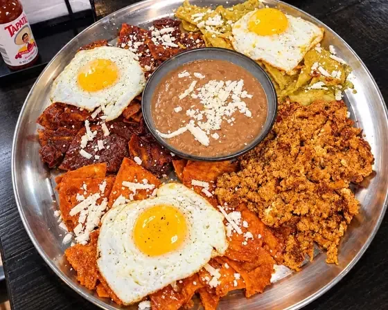Chilaquiles charola with fried eggs, mole, red and green chilaquiles and chorizo at Camacho's Restaurant