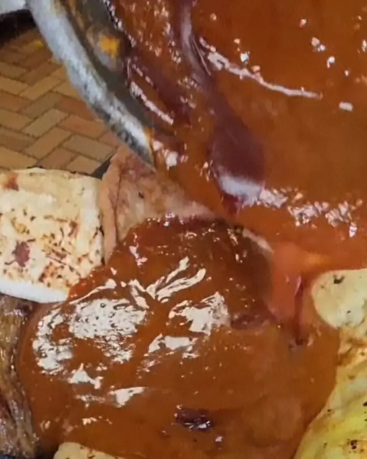 Mole being poured over a molcajete at Camacho's Restaurant